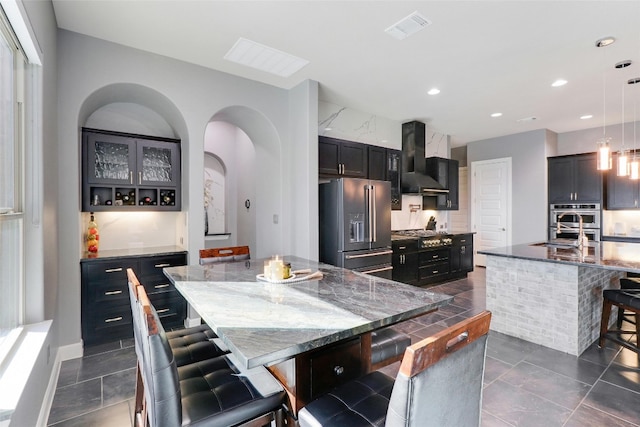 kitchen with hanging light fixtures, a spacious island, and appliances with stainless steel finishes