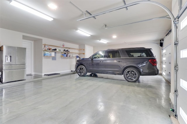 garage featuring stainless steel refrigerator with ice dispenser