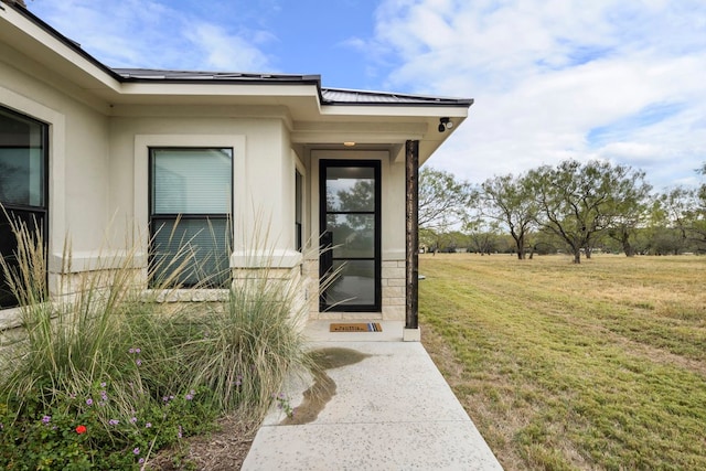 doorway to property with a lawn