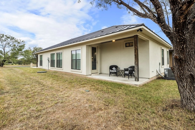 rear view of house with a patio area, a yard, and cooling unit