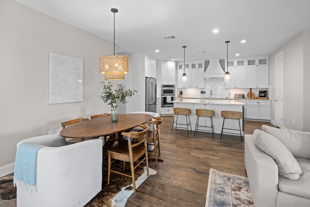 dining area featuring sink, a chandelier, and dark hardwood / wood-style floors