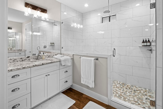 bathroom featuring a shower with door, vanity, and wood-type flooring