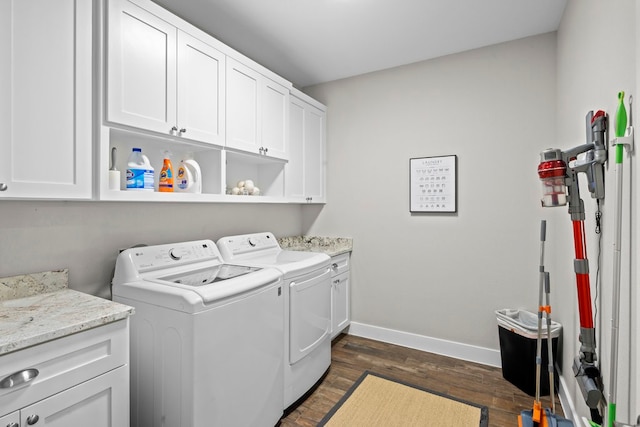 washroom featuring cabinets, washer and dryer, and dark wood-type flooring