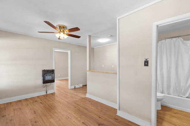 spare room featuring hardwood / wood-style flooring, ceiling fan, and heating unit