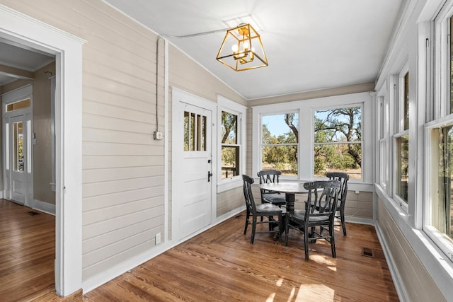 sunroom / solarium with lofted ceiling and a chandelier