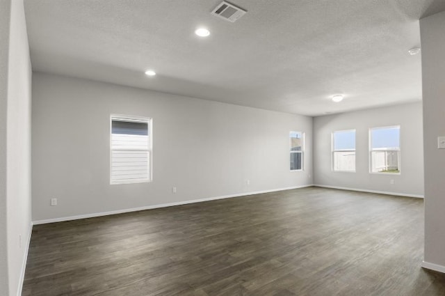 unfurnished room featuring visible vents, baseboards, recessed lighting, dark wood-style floors, and a textured ceiling