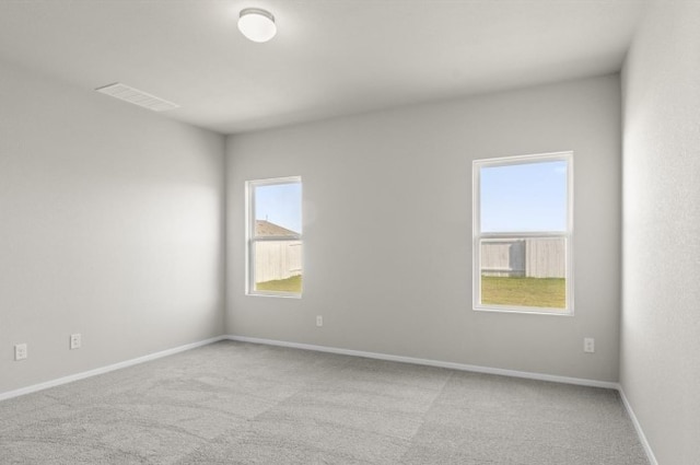 carpeted empty room featuring visible vents and baseboards