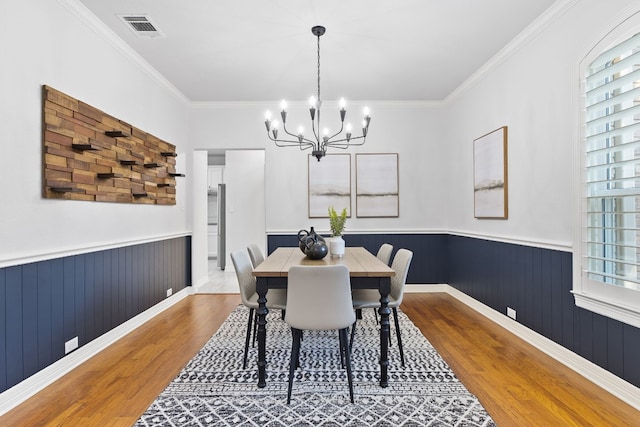 dining space featuring light wood-type flooring, crown molding, and a wealth of natural light