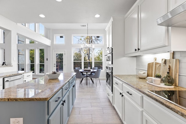 kitchen featuring dishwasher, an inviting chandelier, white cabinets, ventilation hood, and light stone countertops