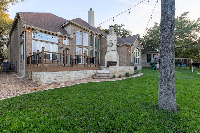 rear view of property featuring a yard and a wooden deck