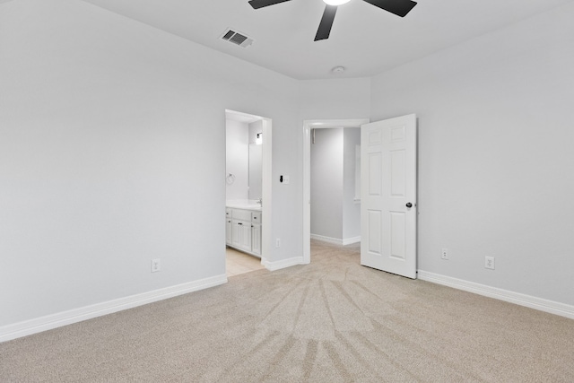 unfurnished bedroom featuring ceiling fan, light colored carpet, and ensuite bathroom