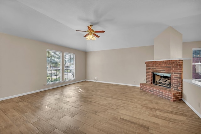 unfurnished living room featuring a brick fireplace, ceiling fan, and light hardwood / wood-style flooring