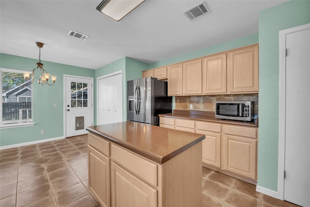 kitchen featuring a center island, decorative backsplash, decorative light fixtures, stainless steel appliances, and a chandelier