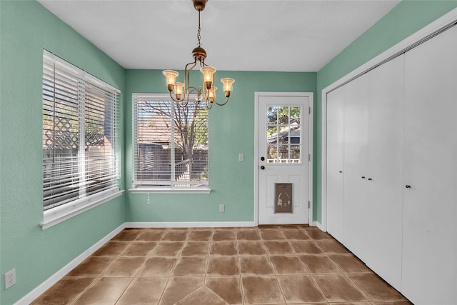 unfurnished dining area featuring a chandelier