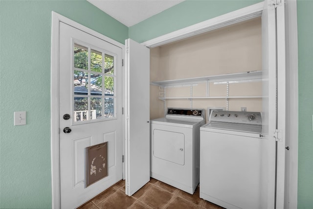 laundry area with washing machine and dryer and dark tile patterned flooring