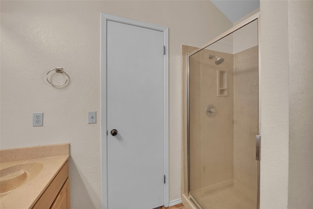 bathroom featuring vanity and an enclosed shower