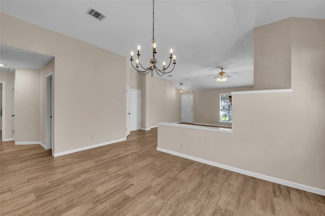 empty room featuring ceiling fan with notable chandelier, lofted ceiling, and light hardwood / wood-style flooring