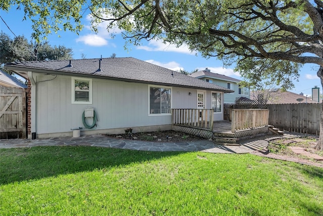 rear view of property with a deck and a yard