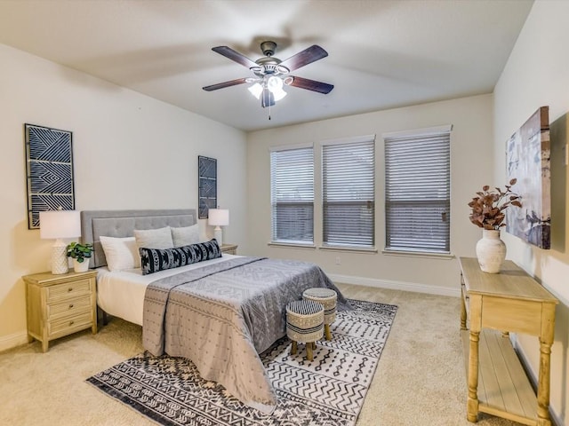 bedroom featuring light colored carpet, ceiling fan, and baseboards