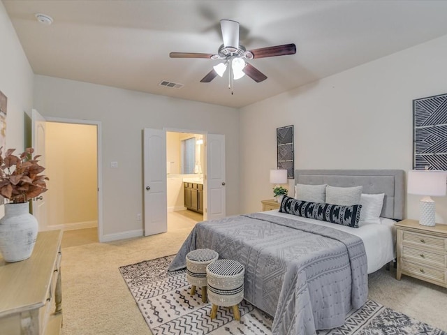 bedroom featuring light carpet, a ceiling fan, visible vents, baseboards, and ensuite bath