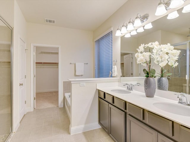 bathroom with visible vents, a sink, a shower stall, and double vanity