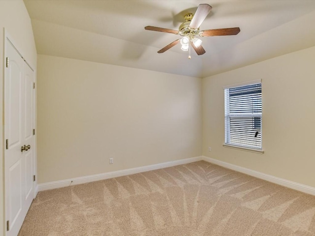 empty room featuring ceiling fan, baseboards, and light colored carpet