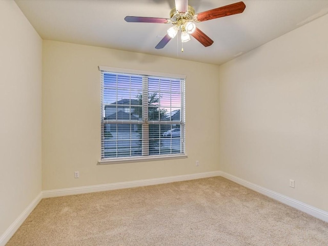 empty room featuring light carpet, ceiling fan, and baseboards