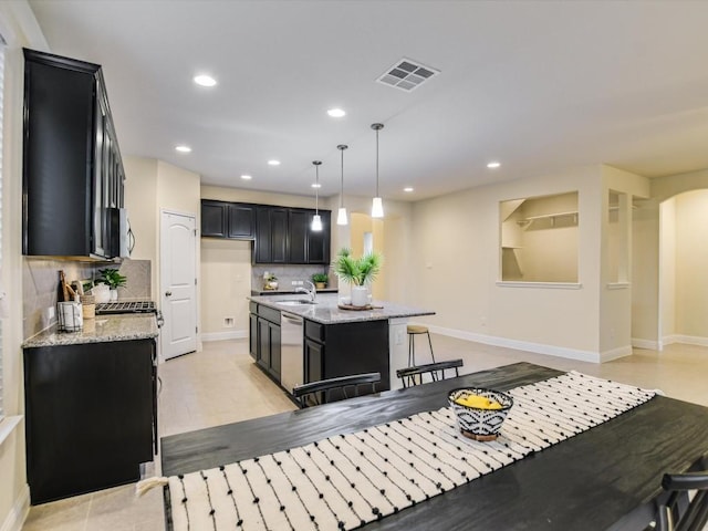 kitchen featuring visible vents, light stone counters, a center island, hanging light fixtures, and stainless steel appliances