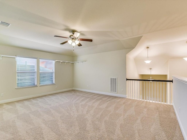 unfurnished room with light carpet, a ceiling fan, visible vents, and baseboards