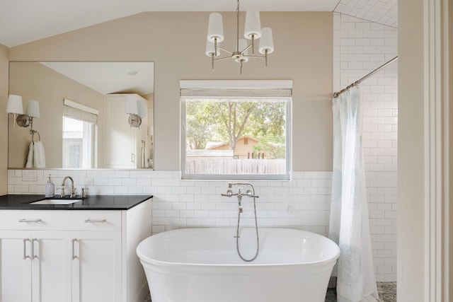 bathroom featuring lofted ceiling, vanity, a bath, and tile walls