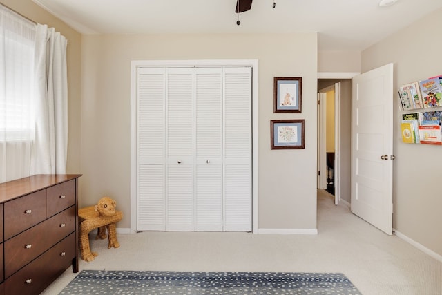 bedroom with multiple windows, ceiling fan, a closet, and carpet floors