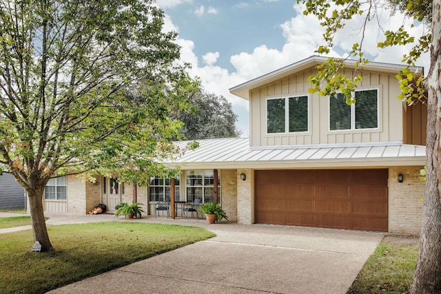 view of front of home with a porch, a garage, and a front yard