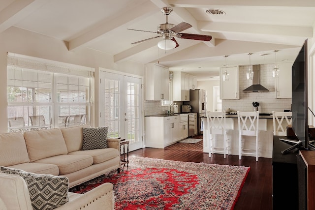 living room with lofted ceiling with beams, ceiling fan, and dark wood-type flooring