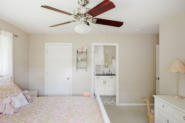 carpeted bedroom with ceiling fan, sink, and ensuite bath