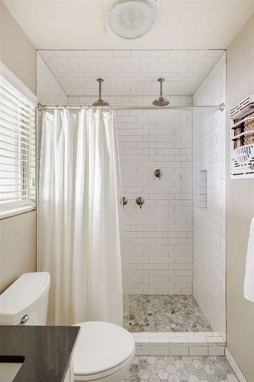 bathroom with a shower with shower curtain, vanity, tile patterned flooring, and toilet