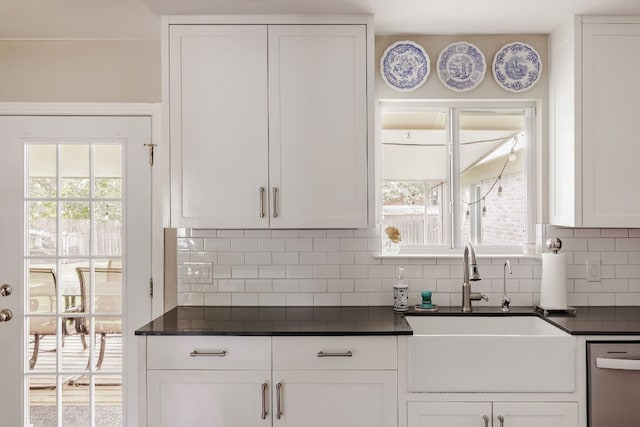 kitchen featuring backsplash, plenty of natural light, white cabinets, and sink