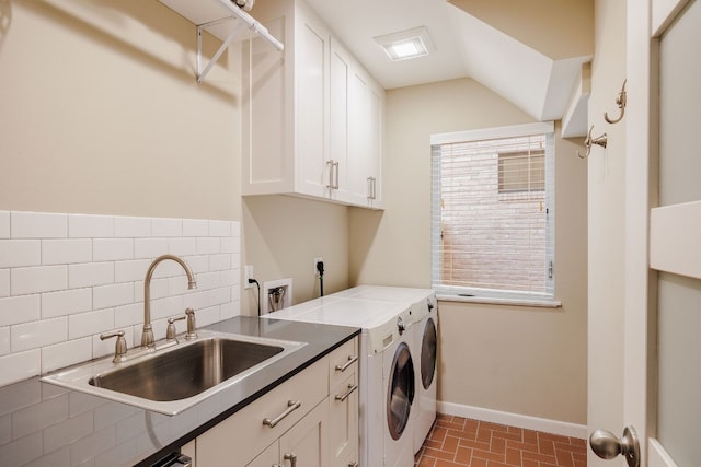 clothes washing area with cabinets, washing machine and dryer, and sink