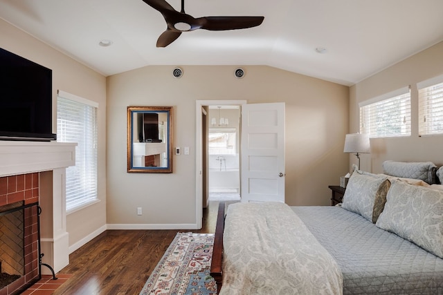 bedroom with lofted ceiling, ensuite bath, ceiling fan, a fireplace, and dark hardwood / wood-style flooring