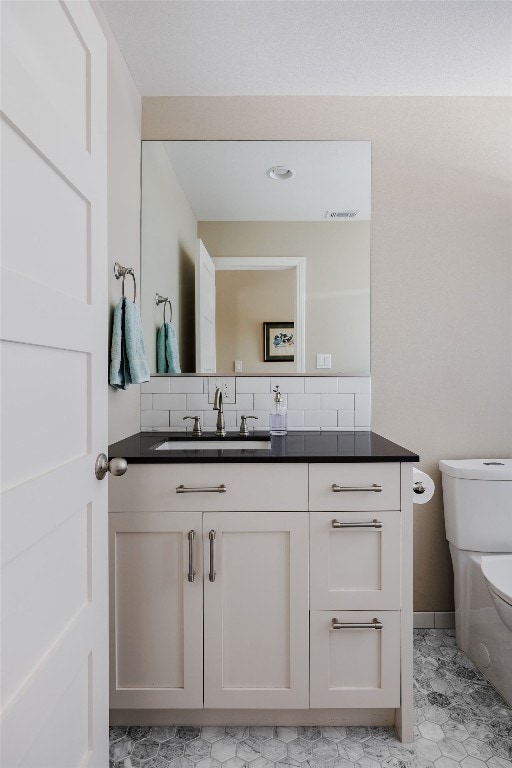 bathroom with tile patterned floors, vanity, and toilet