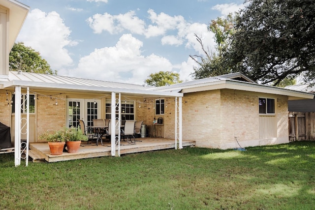 rear view of property featuring a yard and a wooden deck