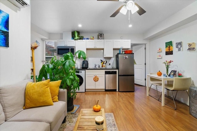 306 E 30th St Unit 102, Austin, TX 78705 - living area featuring a wall unit AC, light wood finished floors, a ceiling fan, recessed lighting, and washer / dryer