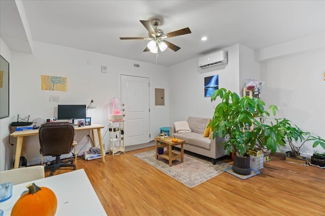 office space with a wall mounted air conditioner, hardwood / wood-style floors, and ceiling fan