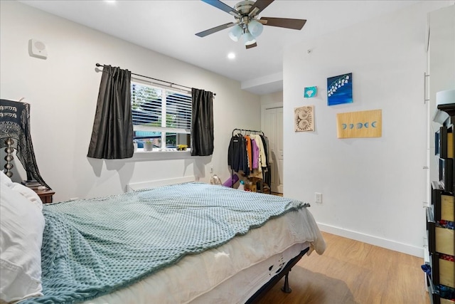 bedroom with a closet, hardwood / wood-style flooring, and ceiling fan