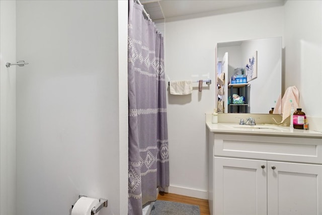 bathroom with curtained shower, vanity, and hardwood / wood-style flooring