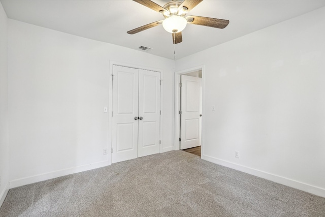 unfurnished bedroom with ceiling fan, a closet, and carpet floors