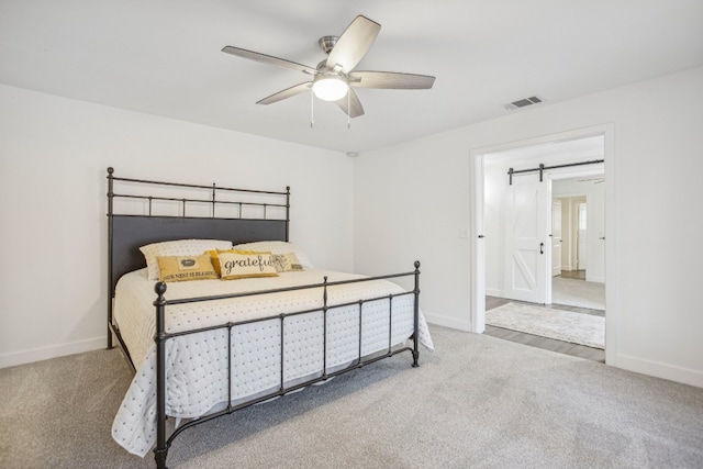 bedroom with carpet, a barn door, and ceiling fan