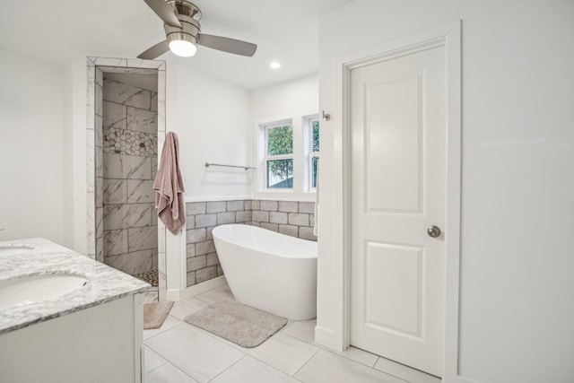 bathroom featuring tile patterned floors, vanity, ceiling fan, tile walls, and plus walk in shower