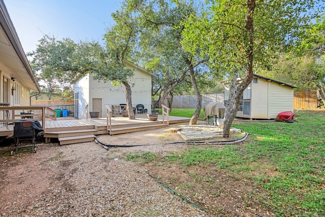 view of yard featuring a deck and a storage unit