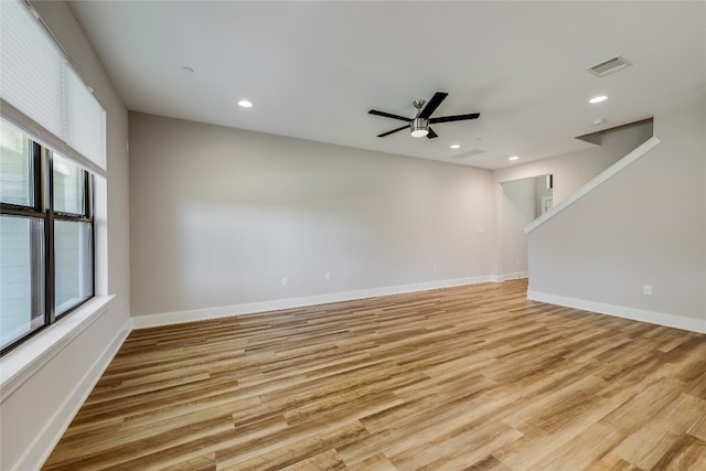 empty room featuring ceiling fan, plenty of natural light, and light hardwood / wood-style floors