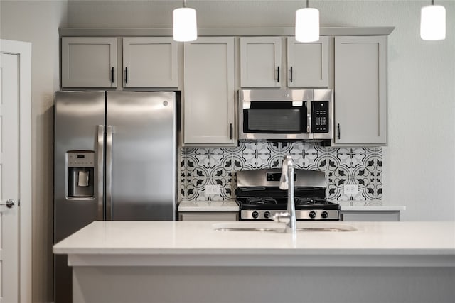 kitchen with decorative backsplash, gray cabinets, and appliances with stainless steel finishes